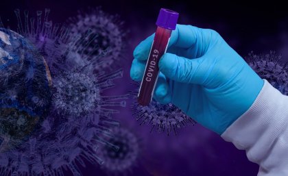 Pixabay: gloved hand holding test tube with cells juxtaposed behind 